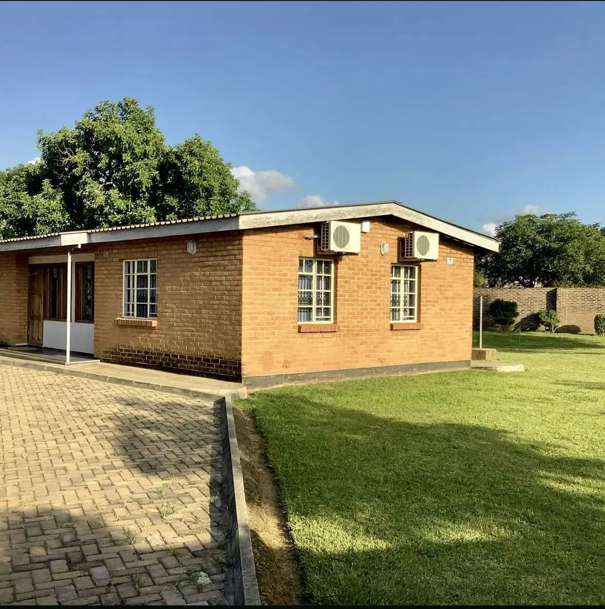 Finished brick building with paved forecourt